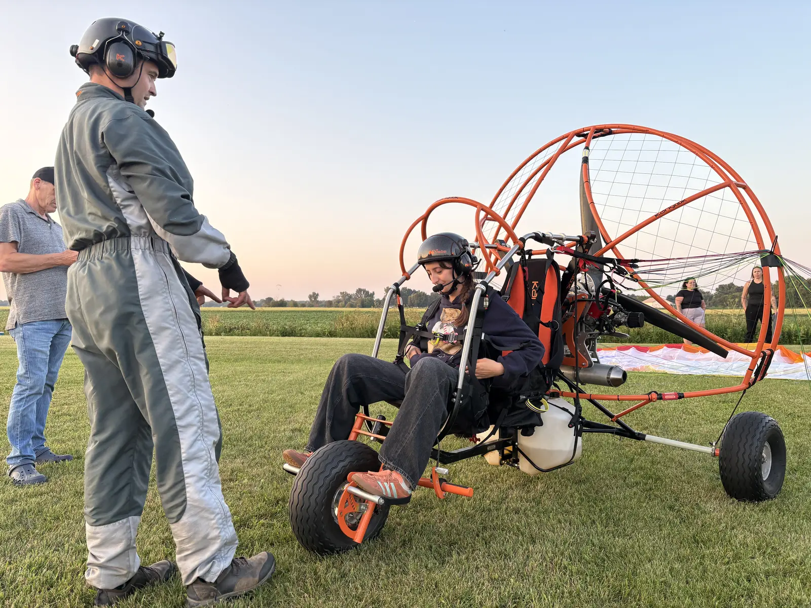 Instructeurs préparant un paramoteur trike orange Kangook sur le terrain