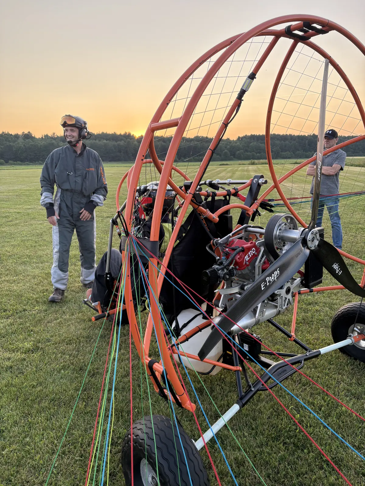Pilote près de la cage ember de son paramoteur au couchant