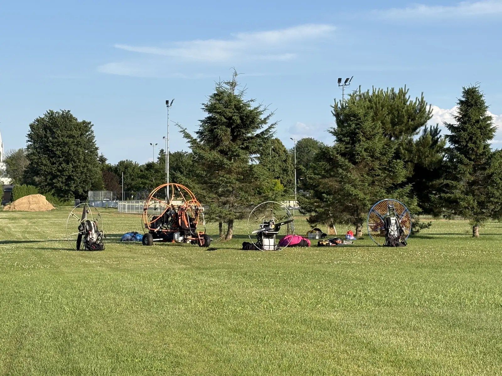 Paramoteurs alignés dans l'herbe sur le terrain de l'école au petit matin